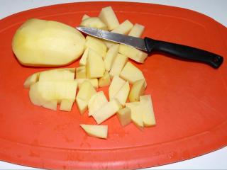 Oloupeme syrové brambory. Na jednu porci pro dospělého počítáme dvě velké, tři střední nebo čtyři menší brambory. Z oloupaných brambor vyřežeme očka, opláchneme je ve studené vodě a rozkrájíme je na kostky asi dvoucentimetrové. Kdo má raději větší kousky brambor v guláši, rozkrájí je na svou oblíbenou velikost. Brambory dáme na talíř nebo do misky.