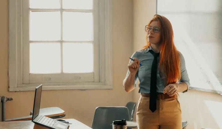 Lektorka přednáší v moderní učebně, ilustrace k výběru MBA studia
