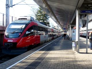 Vlakem je nejrychlejší a nejpohodlnější rovněž cesta přes Vídeň- Meidling. Odtud jezdí příměstské vlaky do Šoproně (Sopron), kde se přestupuje na vlak do Büku (směr Szombathely). Při nákupu mezinárodní jízdenky se může v Česku vyskytnout problém, že drážní systém „nedokáže“ najít stanici Bük. Řešením je koupit si jízdenku do Soproně a tam si dokoupit lístek do Büku. Když to v Soproni nestihneme, je možno koupit si dodatkovou jízdenku ve vlaku (bez příplatku). Průvodčí v této oblasti mluví německy.