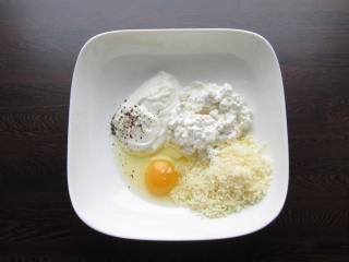 Ve větší misce spolu promíchejte vajíčko, cottage, zakysanou smetanu a najemno nastrouhaný sýr, vytvoříte tak základ na sýrovou nádivku. Směs dle chuti osolte a opepřete.