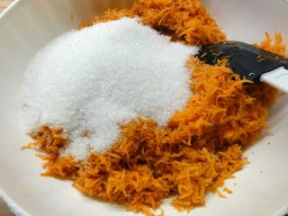 Očištěnou, omytou mrkev nastrouhejte na jemné nudličky a promíchejte s krupicovým cukrem.