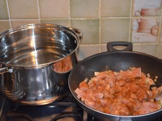 Ke zesklovatělé cibuli přidejte poté ochucené maso a společně je orestujte. Ke kuřecímu masu přidejte také rozmačkaný česnek a restujte jej na pánvi do zlatavé barvy.