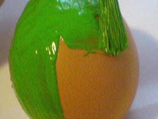 Natření barvou Vajíčko nyní natřeme zvolenou akrylovou barvou. Plochým štětcem nanášíme barvu plynule od jednoho konce k druhému. Příliš netlačíme, abychom nepoškodili křehkou skořápku. Štětec nenamáčíme do barvy příliš, aby nám nevznikaly nehezké mapy. Raději natřeme vajíčko jednou tenkou vrstvou barvy, necháme chvíli zaschnout a přetřeme je ještě jednou. Tentokrát necháme zaschnout důkladně. Vždy si vybírejte syté výrazné barvy. Pastelové odstíny protentokrát vynechte.